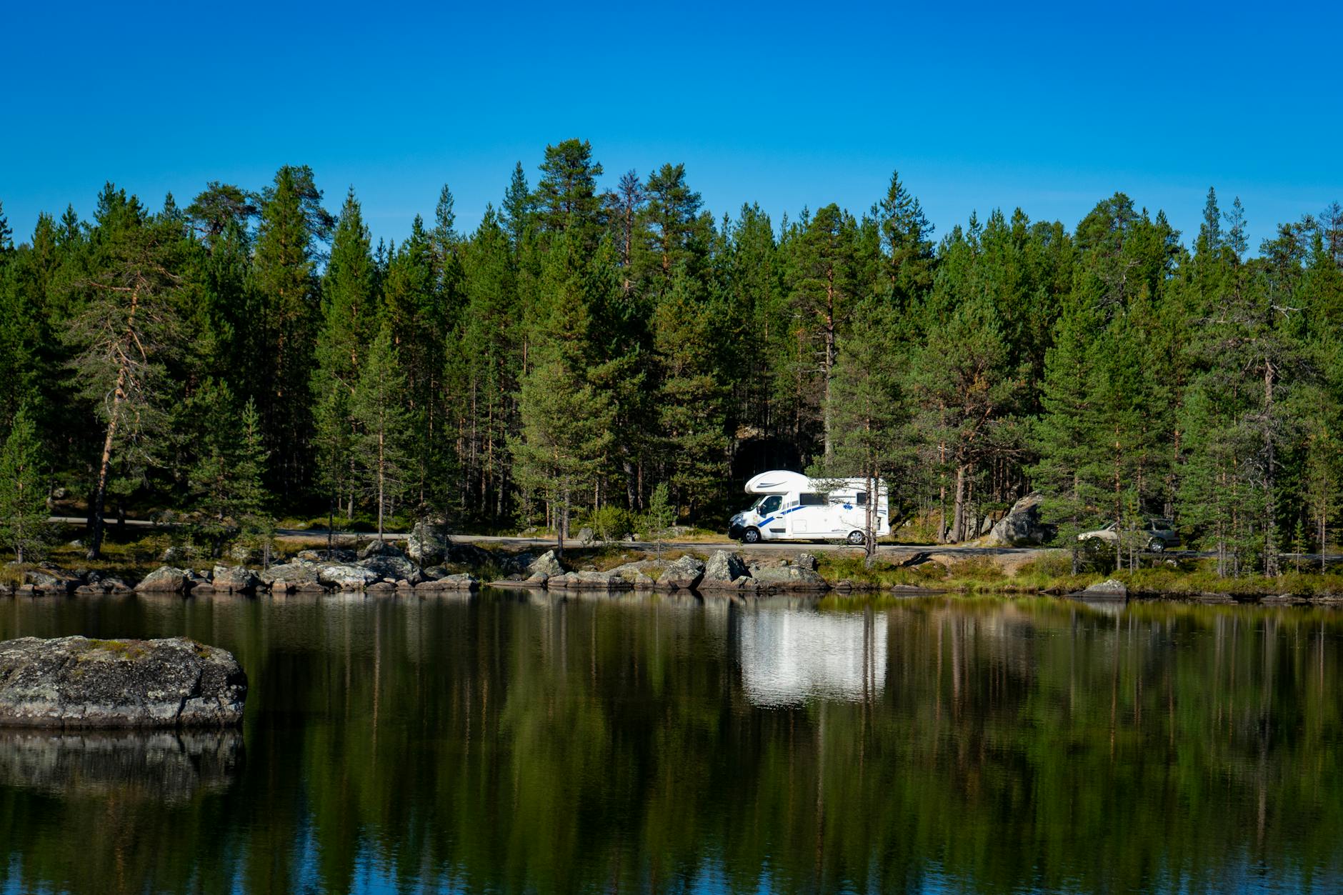 Kamper nad spokojnym jeziorem wśród norweskiego lasu