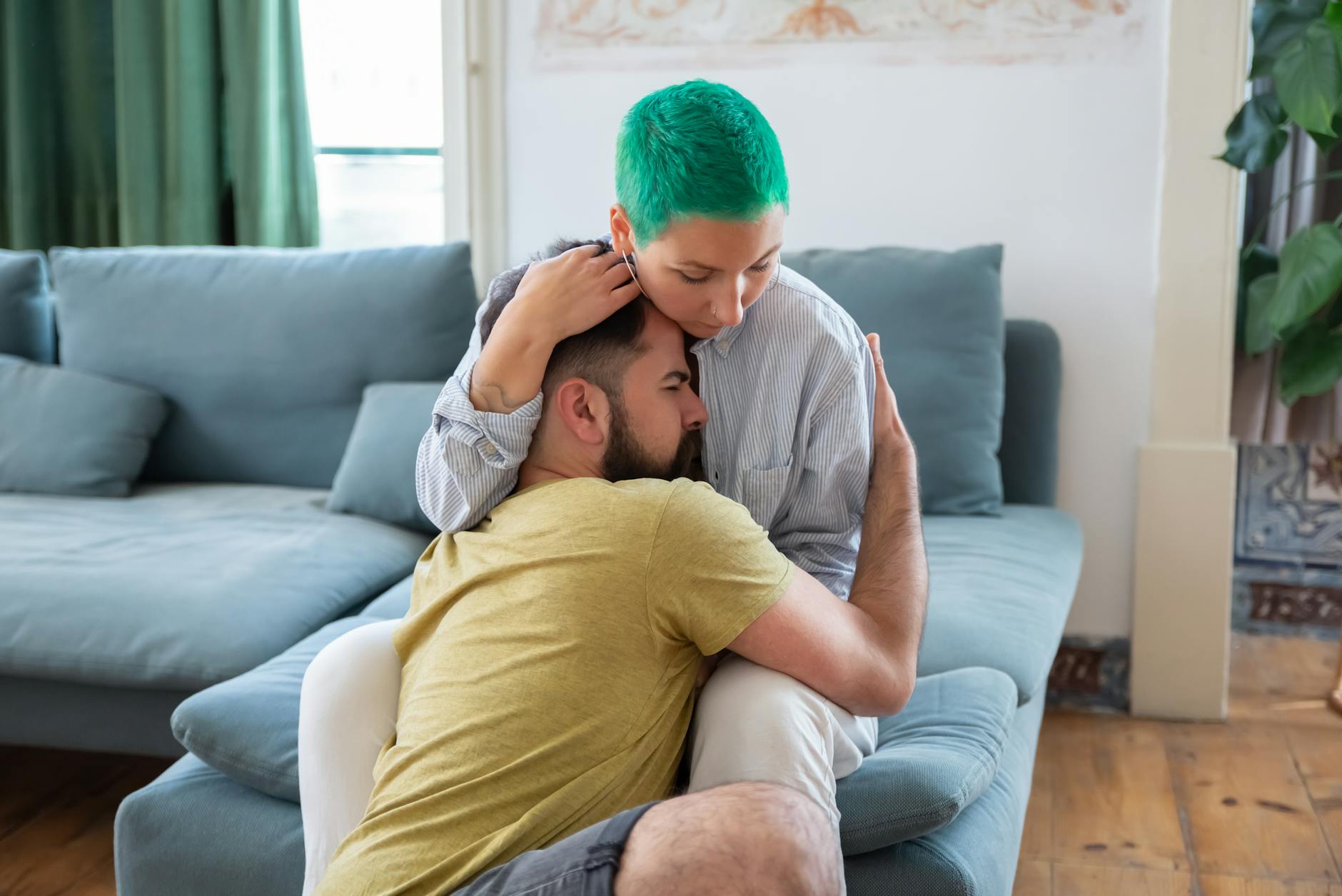 Para tuląca się czule na kanapie w przytulnym salonie