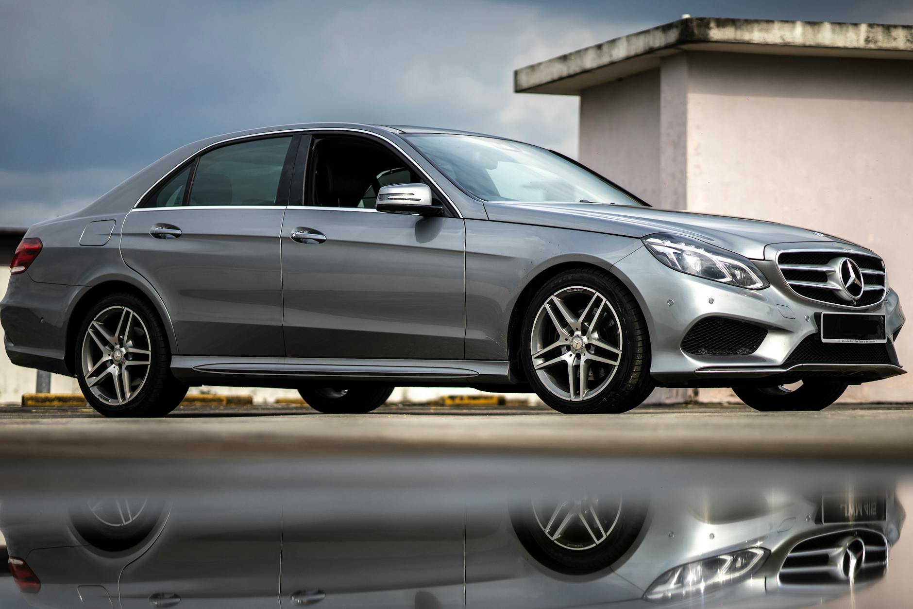 Srebrna limuzyna Mercedes z profilu na ulicy