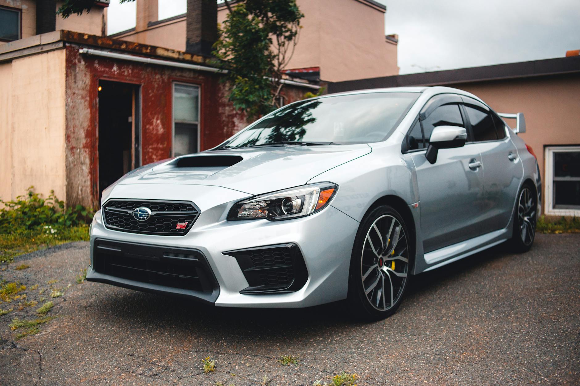 Srebrne Subaru WRX STI zaparkowane na podjeździe przed domem