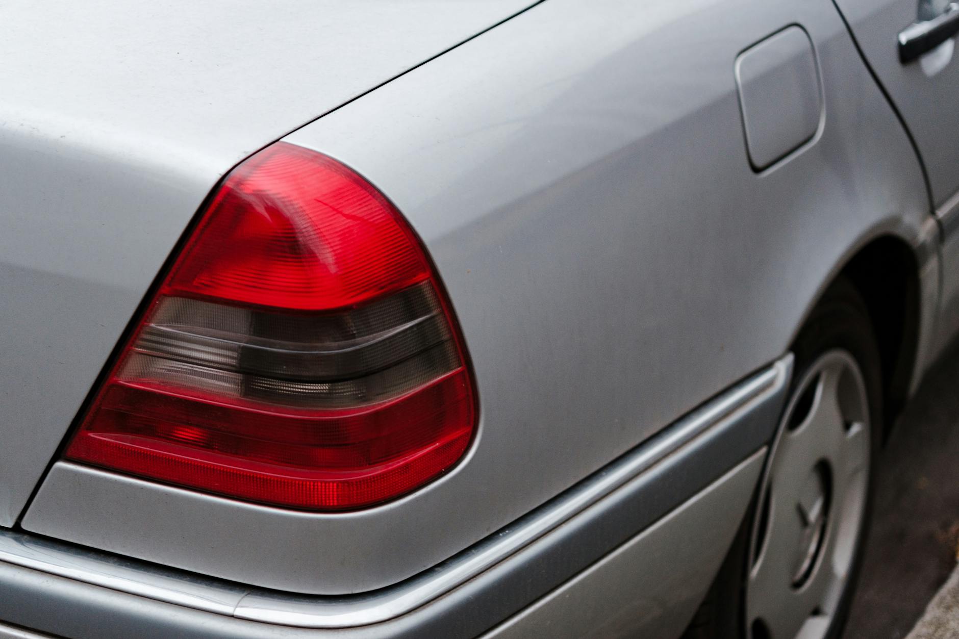 Tylny reflektor i felga srebrnego BMW E90 zaparkowanego przy ulicy