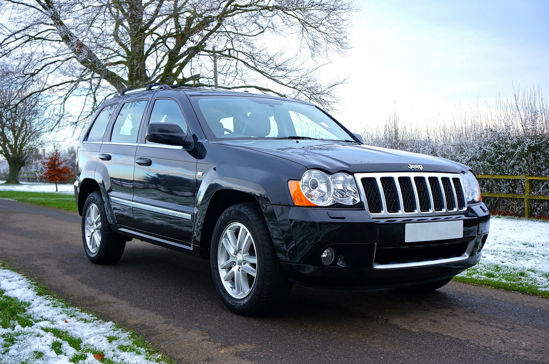 Czarny SUV Skoda zaparkowany na ośnieżonej drodze w lesie