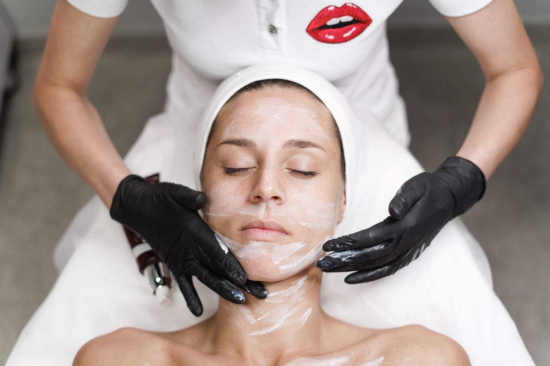 Kobieta podczas relaksującego zabiegu maseczki na twarz w spa
