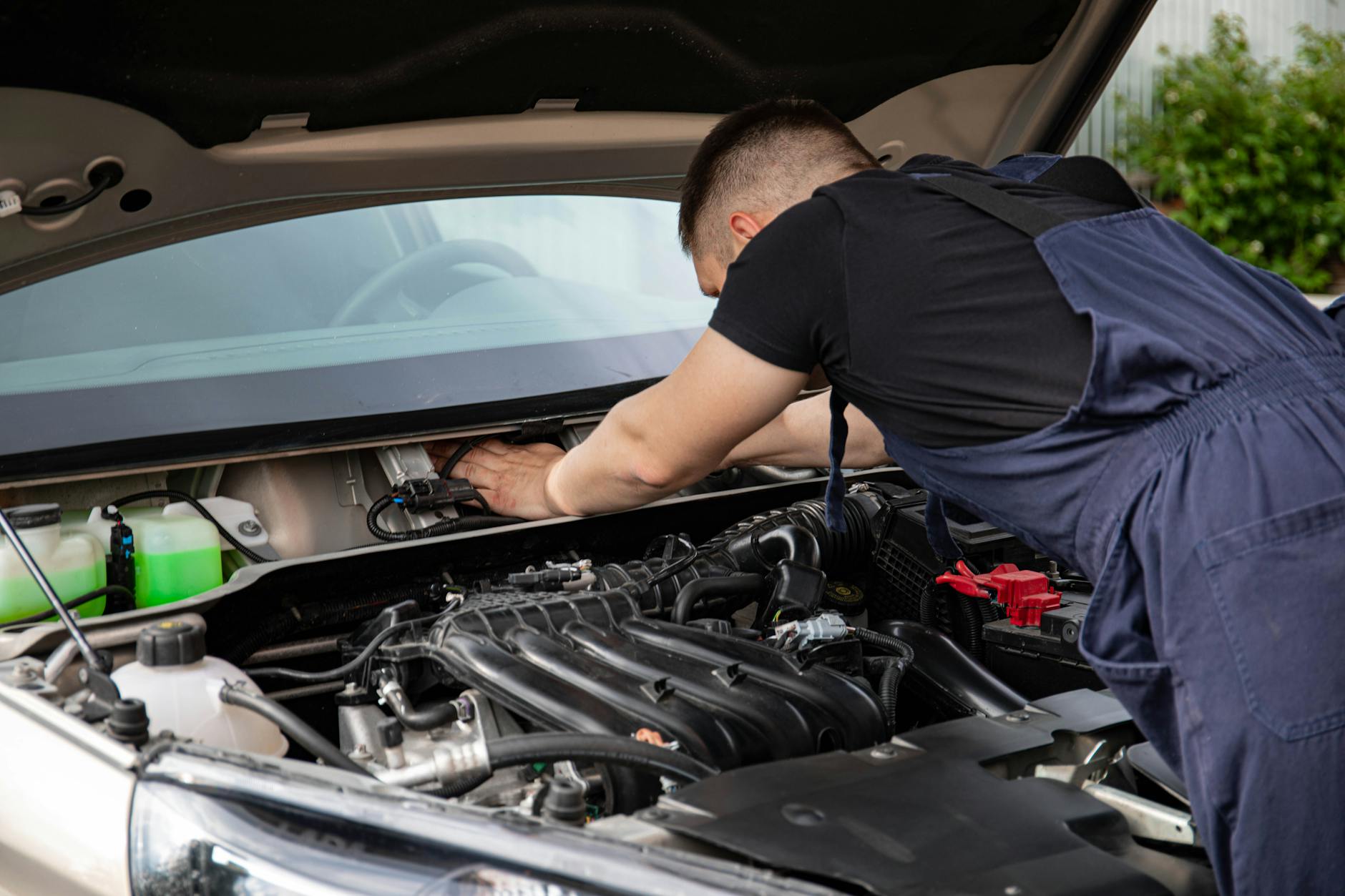 Mechanik serwisuje silnik Subaru, zbliżenie na dłonie i podzespoły