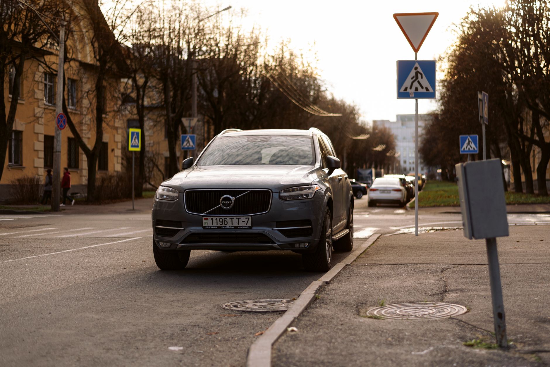 Volvo XC90 zaparkowane przy ulicy w mieście, wokół znaki drogowe