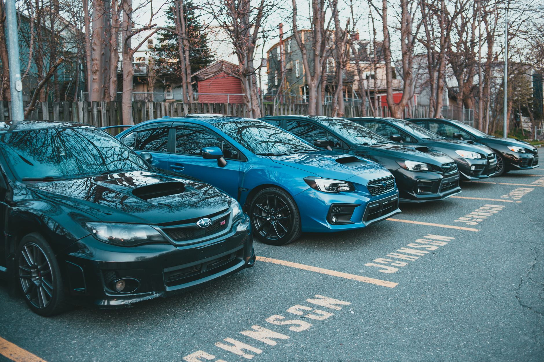 Zaparkowane samochody osobowe różnych marek na leśnym parkingu