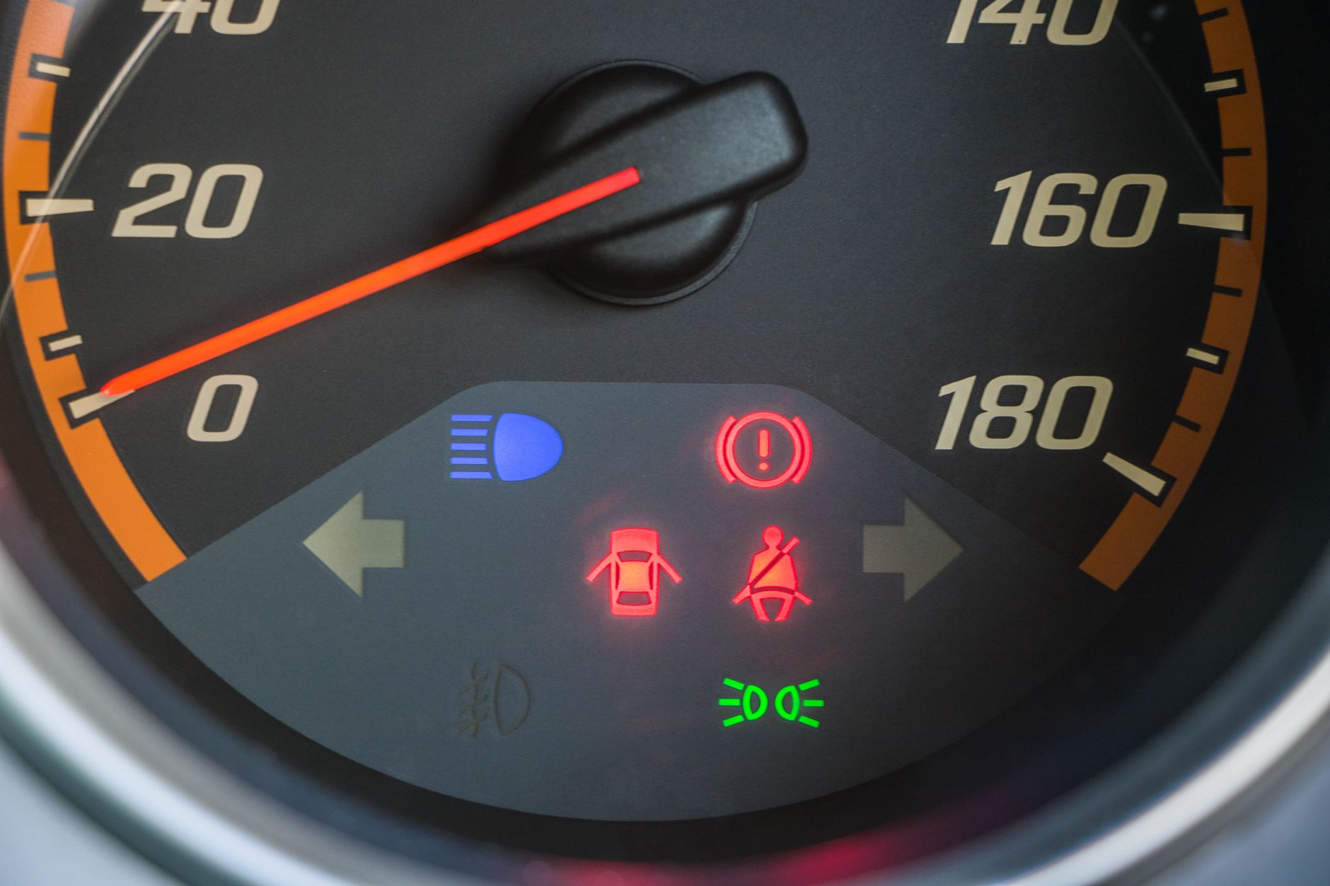 Zbliżenie na prędkościomierz Peugeota z zapalonymi kontrolkami warning